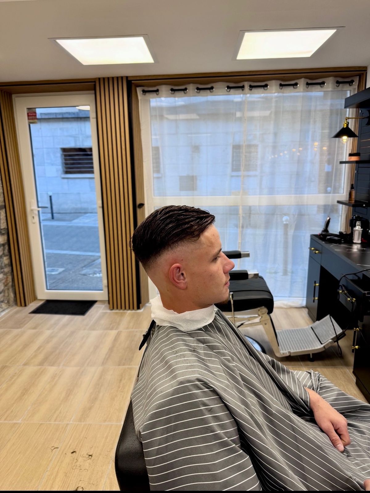 Dégradé à blanc et coiffé en arrière, vue de profil — réalisation Richi Coiffure